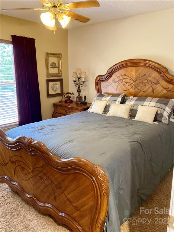 160 Flying Hawk Road Waynesville, NC 28786 - Photo 33 of 45 a bedroom with a bed and a chandelier
