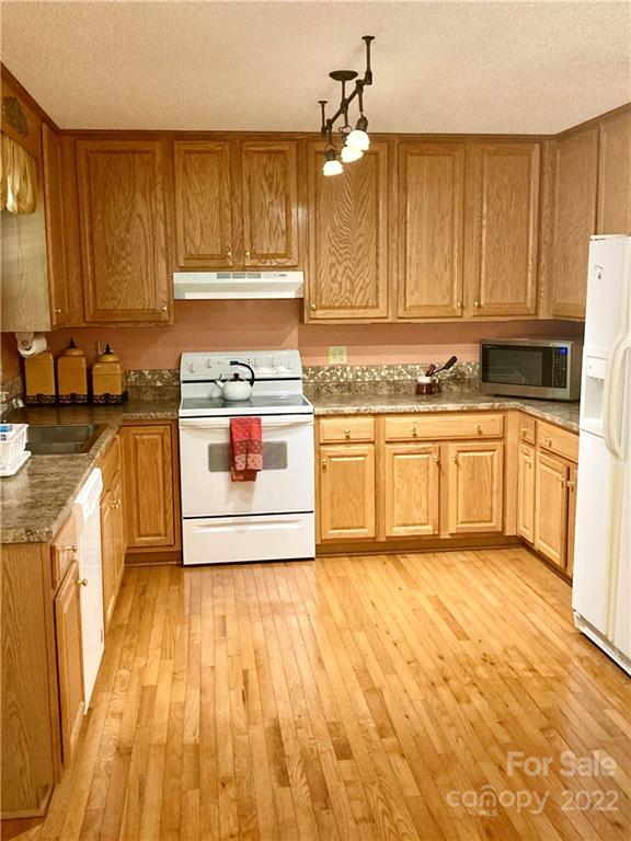 160 Flying Hawk Road Waynesville, NC 28786 - Photo 7 of 45 a kitchen with stainless steel appliances a stove a sink and white cabinets