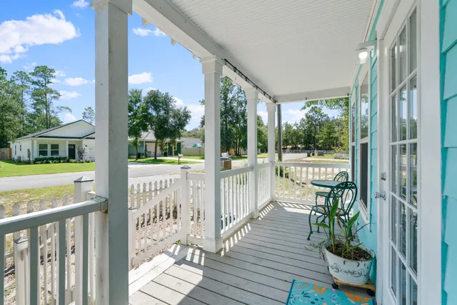 a view of a porch with wooden floor and floor to ceiling window