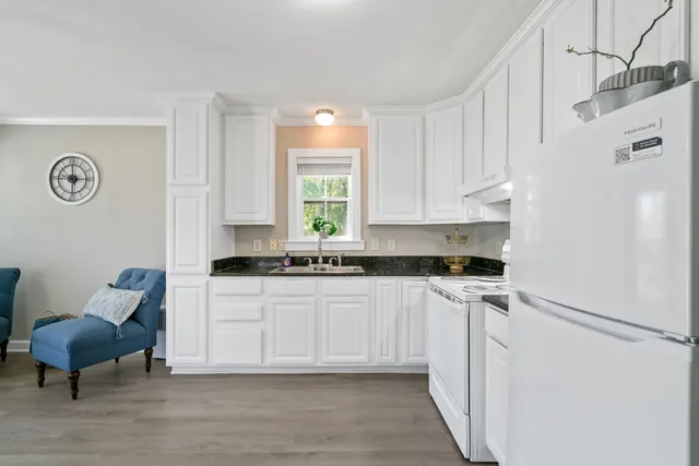 a kitchen with stainless steel appliances a stove a refrigerator and a white cabinets