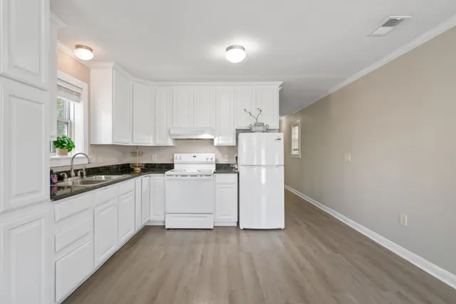 a kitchen with cabinets and wooden floor