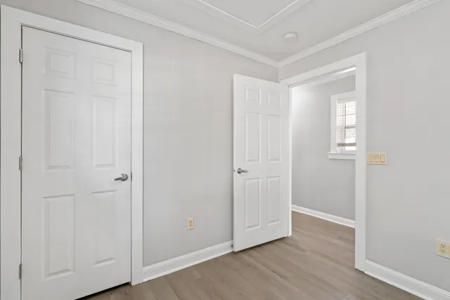 an empty room with wooden floor & closet area