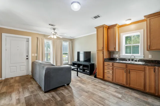 a living room with stainless steel appliances granite countertop furniture and a flat screen tv