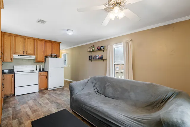 a living room with furniture and a kitchen area