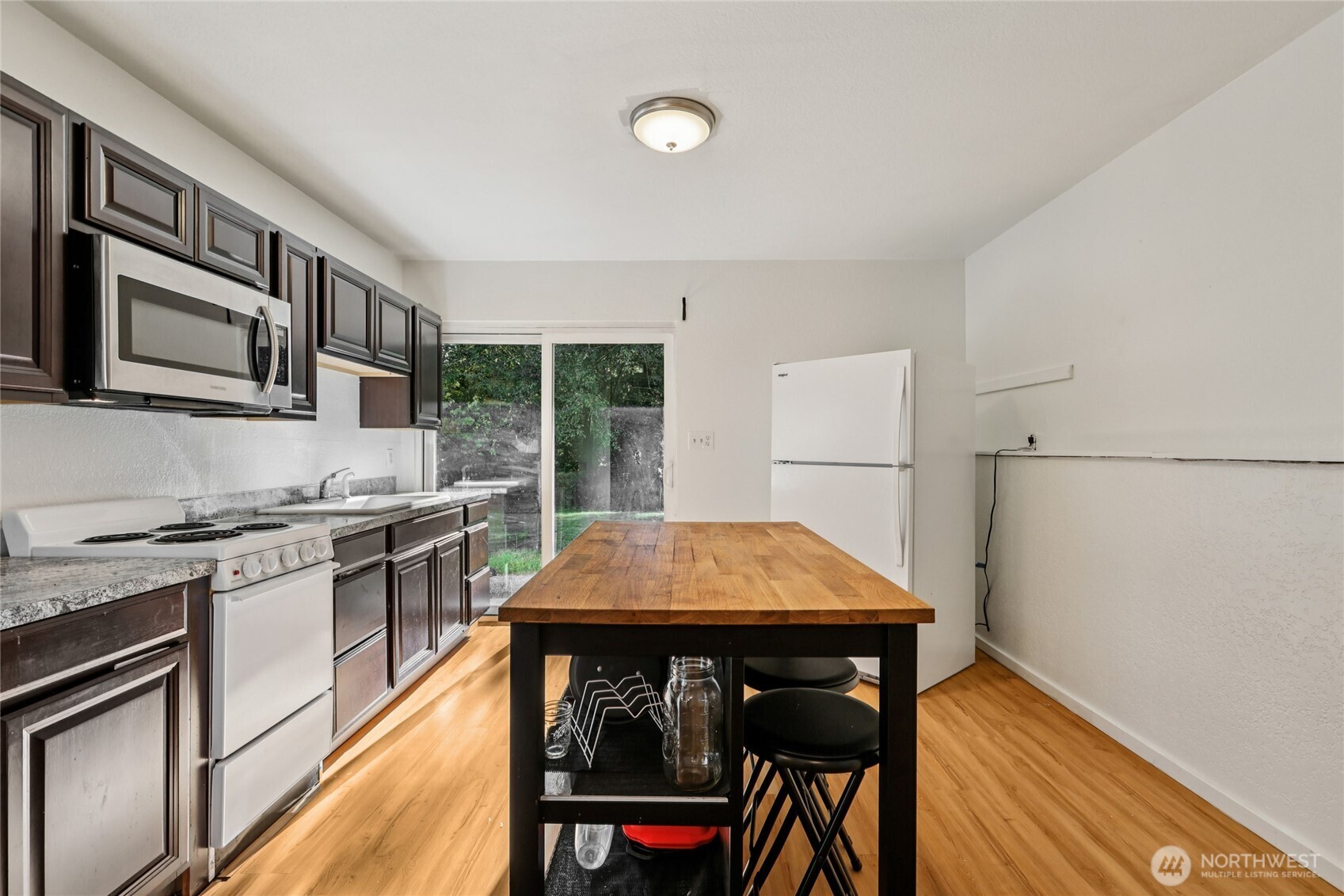 8032 71st Place Southeast Snohomish, WA 98290 - Photo 20 of 32 a kitchen with stainless steel appliances granite countertop a stove a sink dishwasher and a microwave oven with cabinets