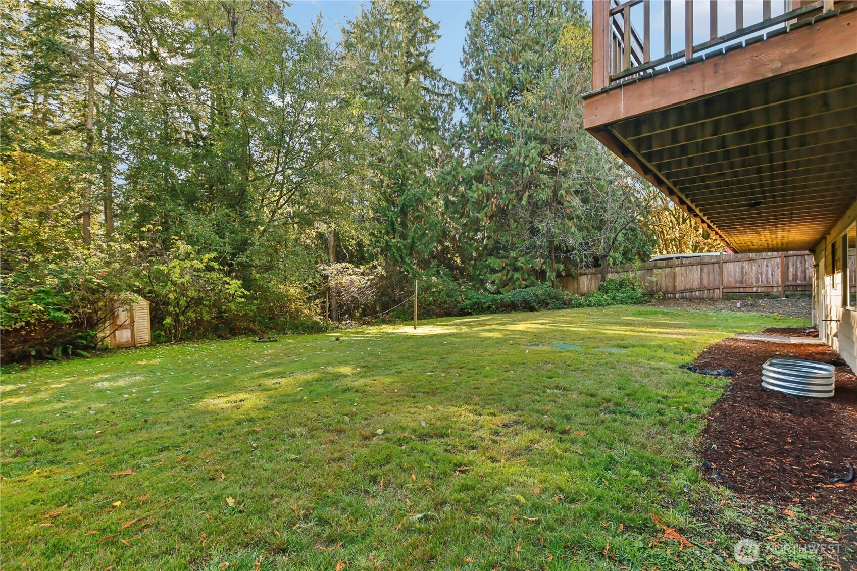 8032 71st Place Southeast Snohomish, WA 98290 - Photo 30 of 32 a view of a backyard with table and chairs and wooden fence