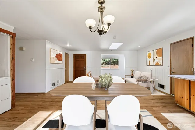 a view of a dining room with furniture a chandelier and wooden floor