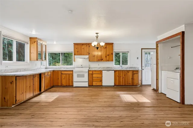 a large kitchen with stainless steel appliances granite countertop a large counter top a sink and a refrigerator