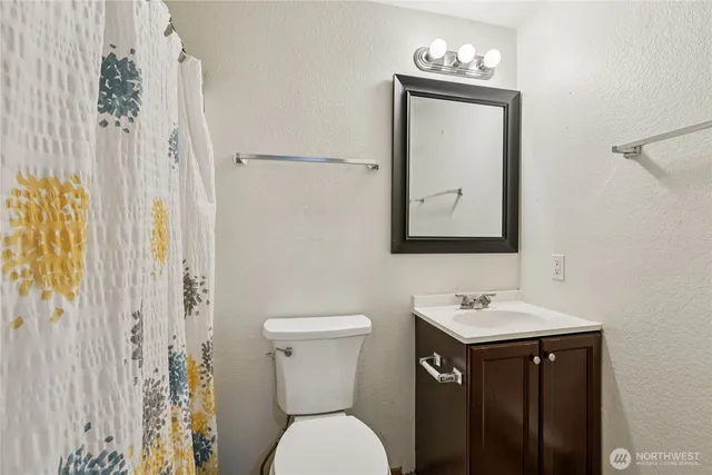 a bathroom with a toilet a sink and a mirror