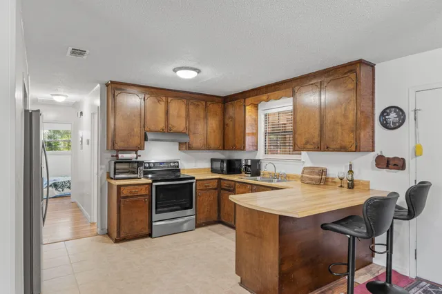 a kitchen with stainless steel appliances granite countertop a stove and a sink