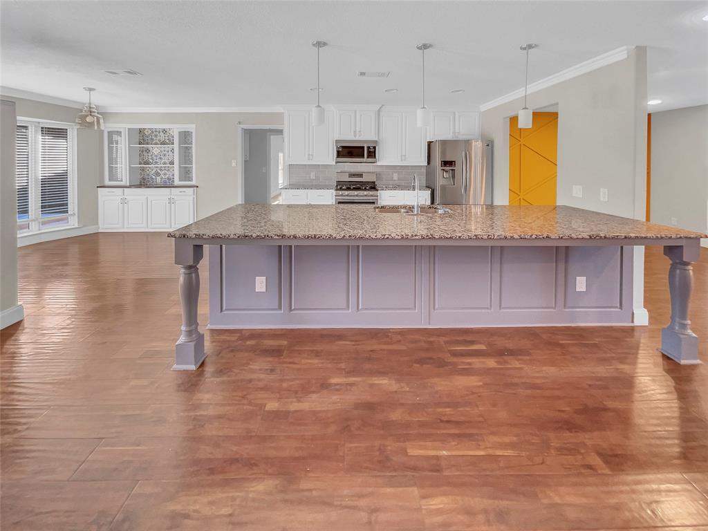 1736 Reynoldston Lane Dallas, TX 75232 - Photo 15 of 17 a view of kitchen with wooden floor and window