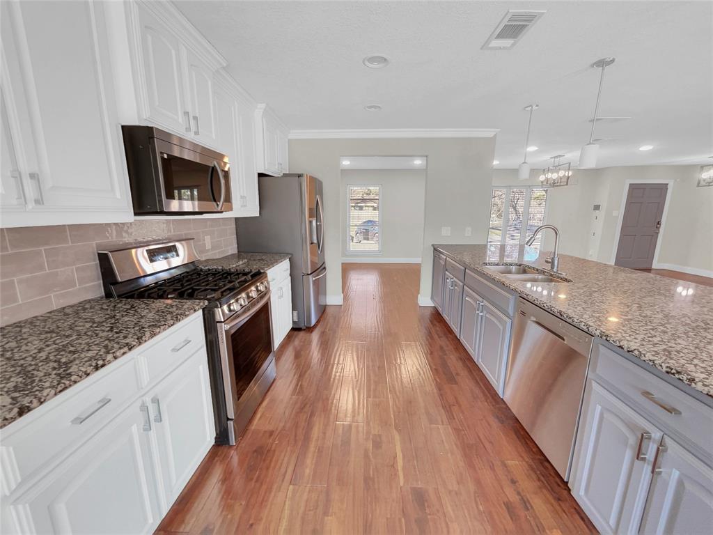 1736 Reynoldston Lane Dallas, TX 75232 - Photo 2 of 17 a large kitchen with granite countertop a large counter top appliances and cabinets