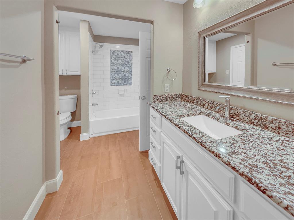 1736 Reynoldston Lane Dallas, TX 75232 - Photo 4 of 17 a bathroom with a granite countertop sink and a mirror