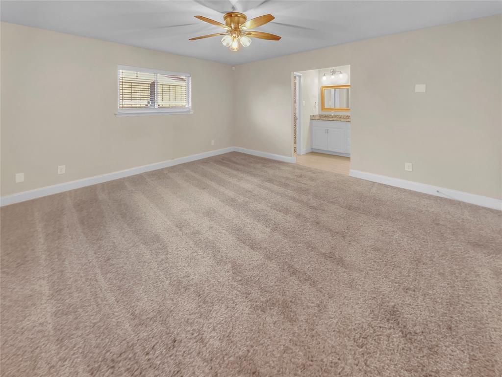 1736 Reynoldston Lane Dallas, TX 75232 - Photo 7 of 17 en empty room with windows and ceiling fan
