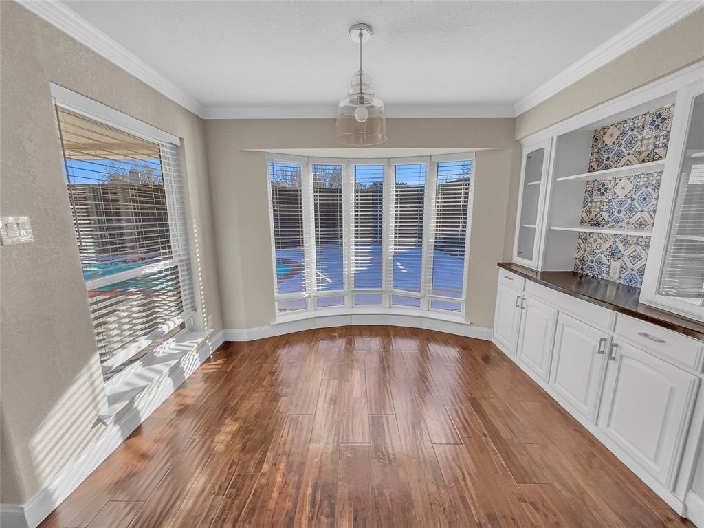 1736 Reynoldston Lane Dallas, TX 75232 - Photo 9 of 17 a view of an empty room with a window and wooden floor