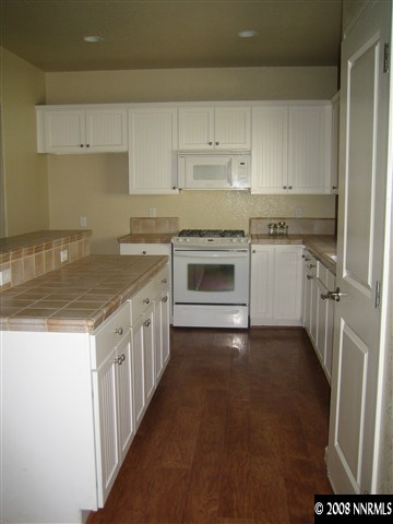 3270 Paragon Place Reno, NV 89509 - Photo 5 of 9 a kitchen with a stove and white cabinets