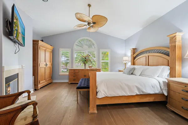 a bedroom with a bed a chandelier and dresser
