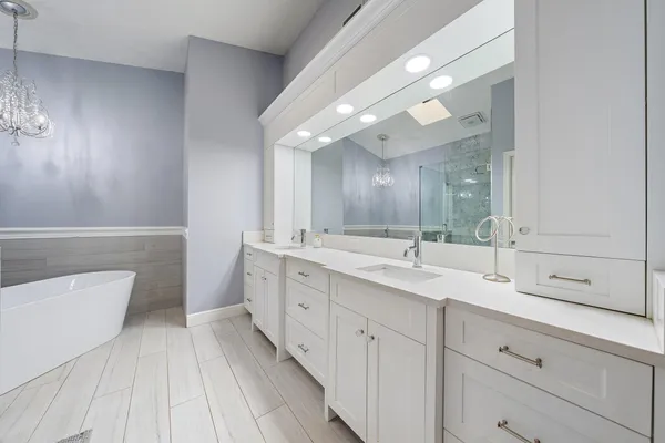 a spacious bathroom with a double vanity sink a mirror and a toilet