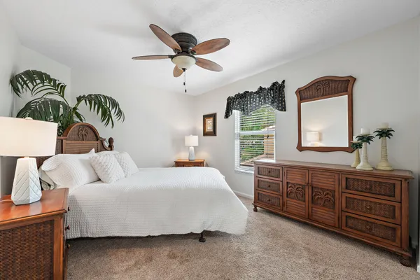 a bedroom with a bed dresser and window