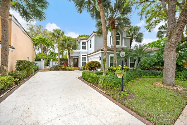 a front view of a house with a yard and potted plants