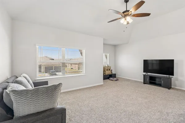 a living room with furniture and a ceiling fan