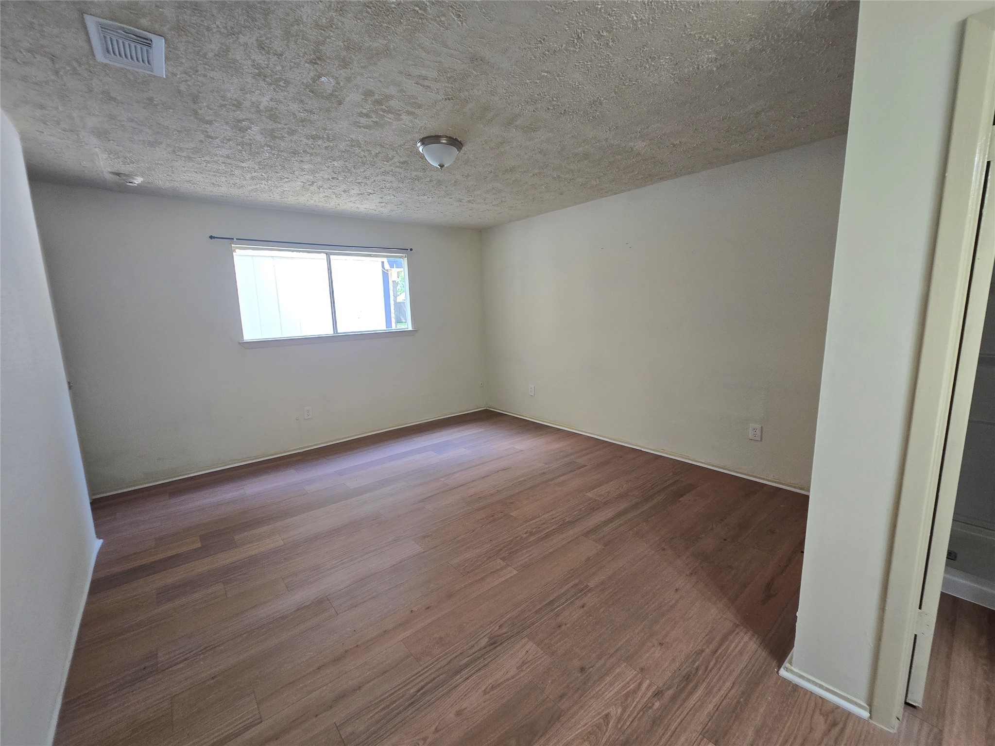 16331 Dew Drop Lane Houston, TX 77095 - Photo 14 of 20 an empty room with wooden floor and windows