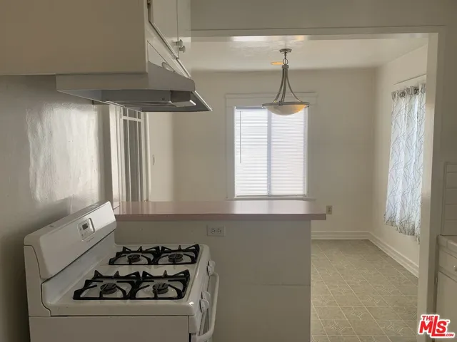 a kitchen with a stove a sink and a window