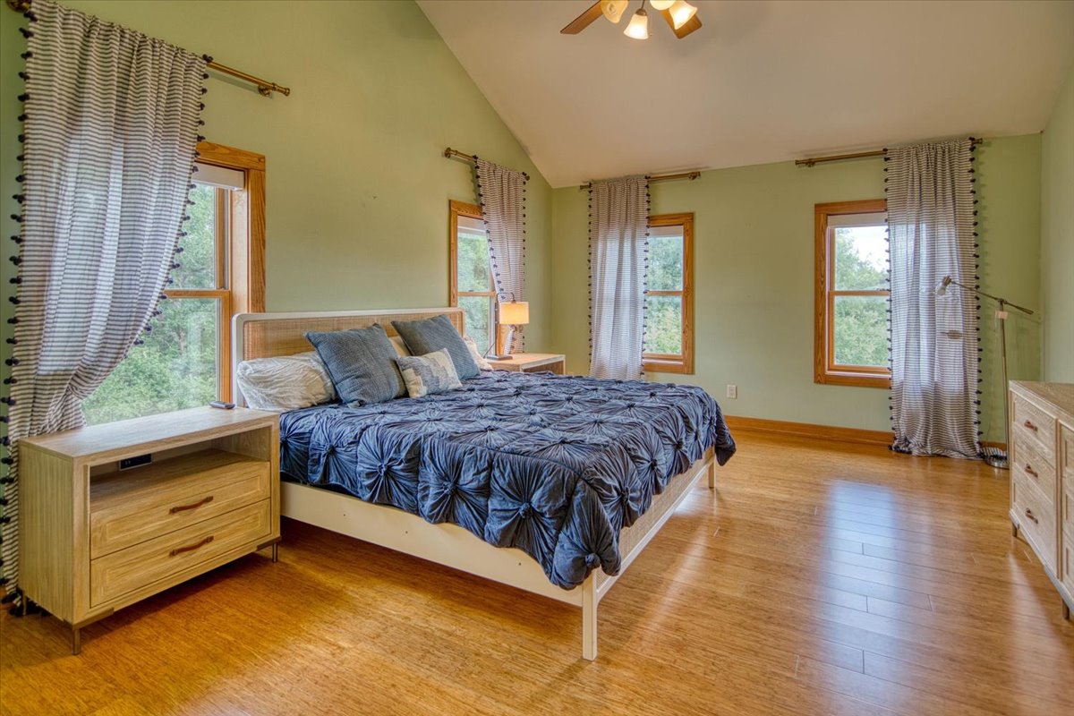 301 Blessing Ranch Road Liberty Hill, TX 78642 - Photo 21 of 40 a spacious bedroom with a bed and wooden floor
