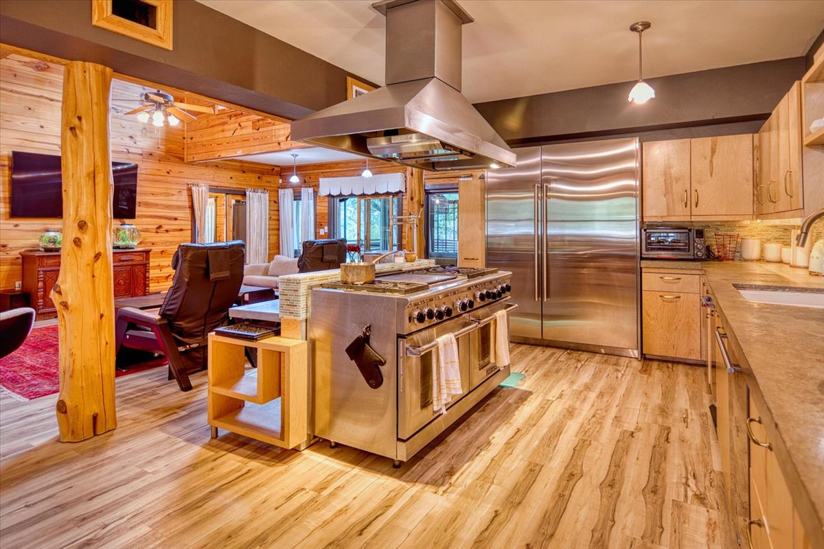 301 Blessing Ranch Road Liberty Hill, TX 78642 - Photo 9 of 40 a kitchen with stainless steel appliances a stove a sink dishwasher and white cabinets with wooden floor