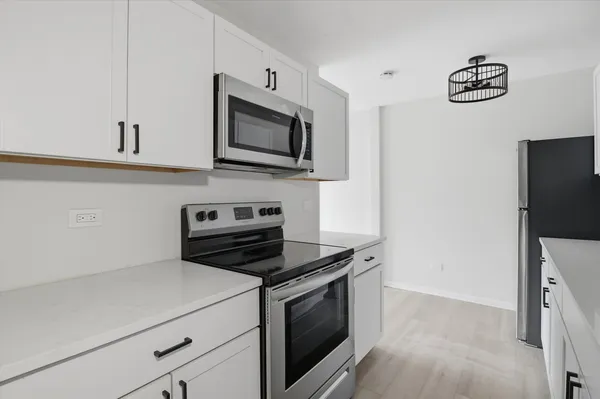 a kitchen with stainless steel appliances a white stove top oven a sink and dishwasher