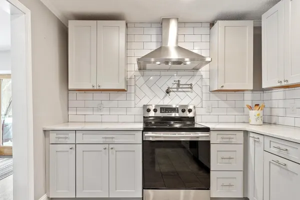 a kitchen with white cabinets and appliances