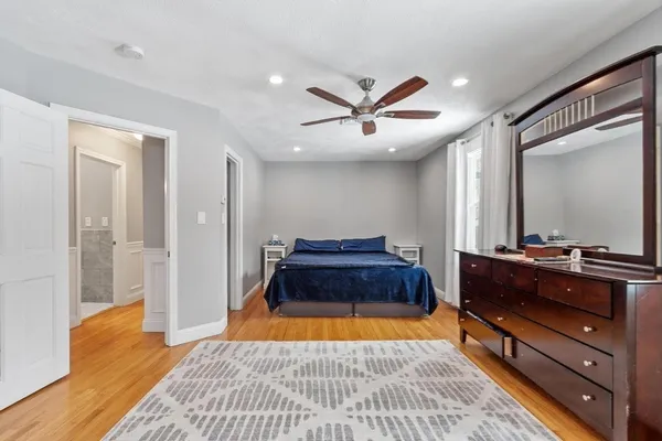 a spacious bedroom with a bed and a dresser