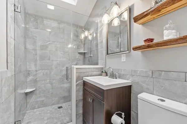 a bathroom with a sink a toilet and shower