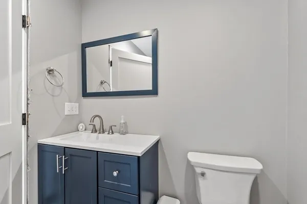 a bathroom with a toilet a sink and mirror