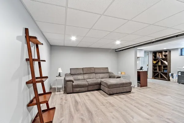 a living room with furniture a wooden floor and a book shelf