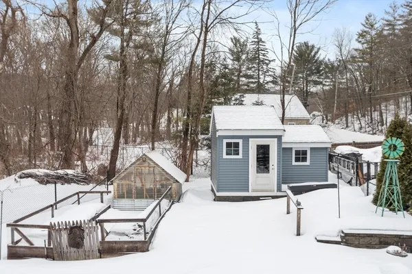 a view of a patio with couches and chairs with wooden floor and fence