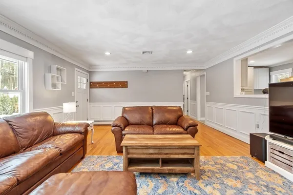 a living room with furniture a flat screen tv and a window