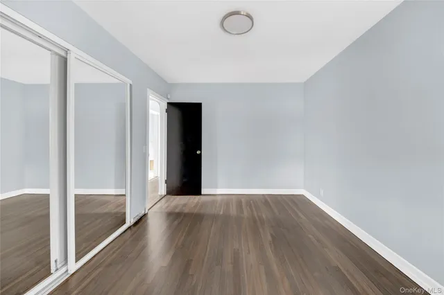 a view of a big room with wooden floor and windows