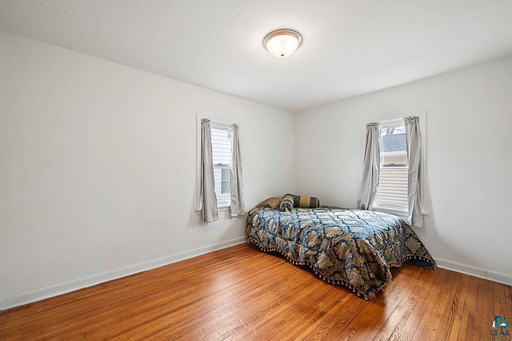 122 3rd Street Cloquet, MN 55720 - Photo 16 of 42 Room featuring wood-finish flooring, white walls, and a semi-flush mount ceiling light fixture