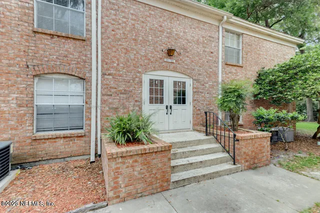 a front view of a house with plants