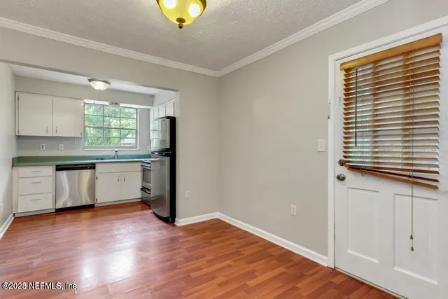 a kitchen with granite countertop wooden floors and white cabinets