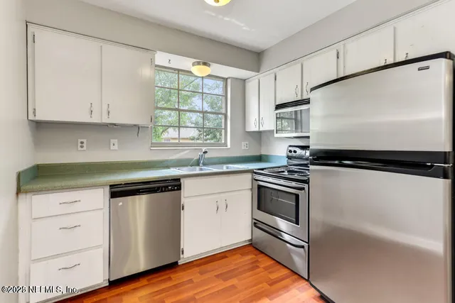a kitchen with cabinets appliances and a window