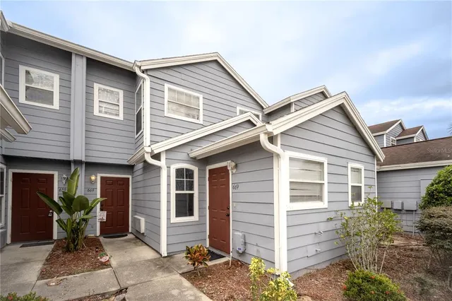 a view of house with potted plants and a bench