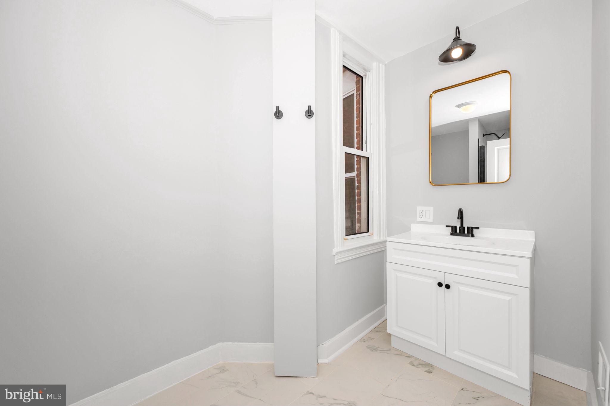 230 South Market Street, Unit 1 Frederick, MD 21701 - Photo 17 of 27 a bathroom with a sink a mirror and a vanity