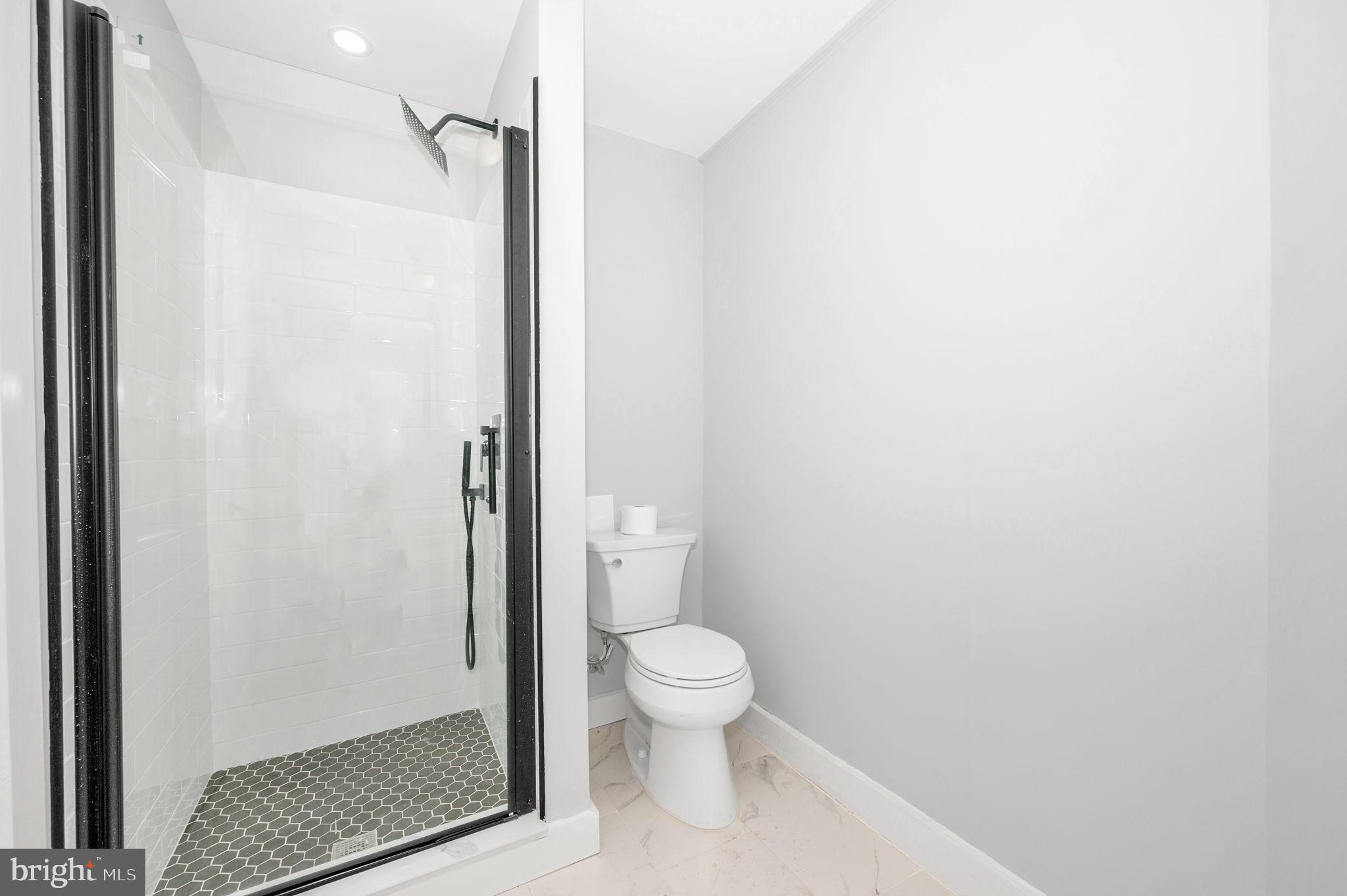 230 South Market Street, Unit 1 Frederick, MD 21701 - Photo 18 of 27 a bathroom with a granite countertop toilet and a shower