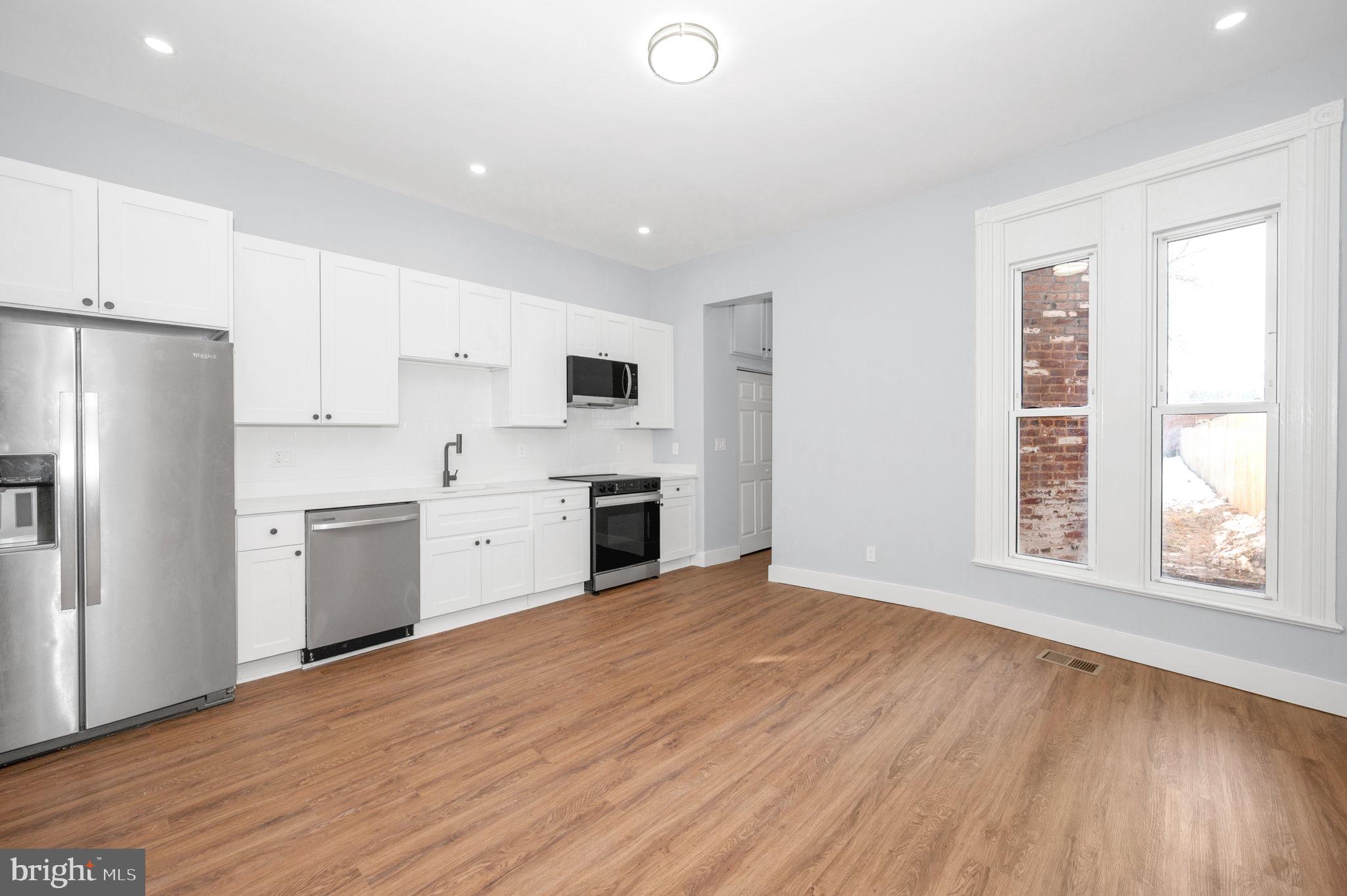 230 South Market Street, Unit 1 Frederick, MD 21701 - Photo 7 of 27 a kitchen with a white cabinets and wooden floor