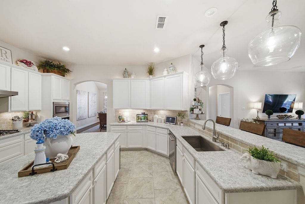 9614 Carson Lane Iowa Colony, TX 77583 - Photo 15 of 50 Plenty of cabinet space with over and under cabinet lighting! This kitchen also hosts a undermount stainless composite sink with touchless gooseneck faucet and stainless appliances throughout!