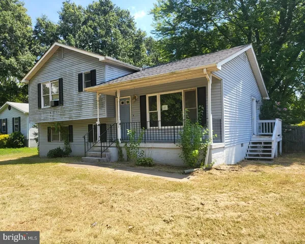 a view of a house with a yard and sitting area