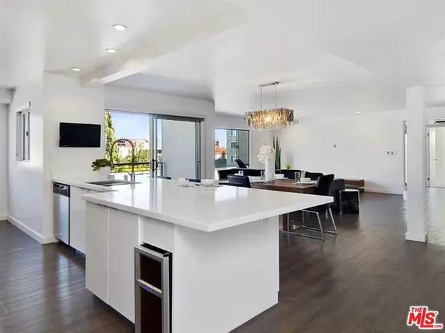a kitchen with kitchen island a stove a table and chairs in it