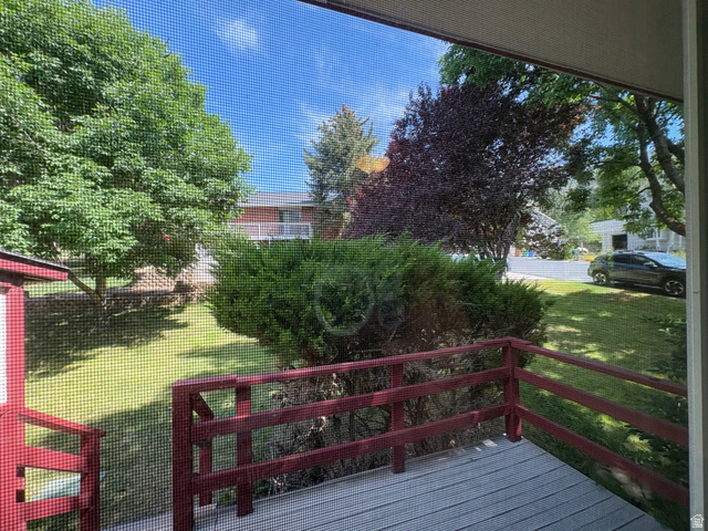 595 Meadowlark Road Orem, UT 84097 - Photo 26 of 87 Private outdoor decking with red-painted railings overlooking a green lawn and mature landscaping